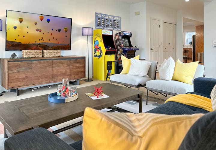 Retro Arcade + Cozy Lounge Combo 
This vibrant family room features comfy seating, a smart TV, and classic arcade games—perfect for group hangs, game nights, or screen time with style.