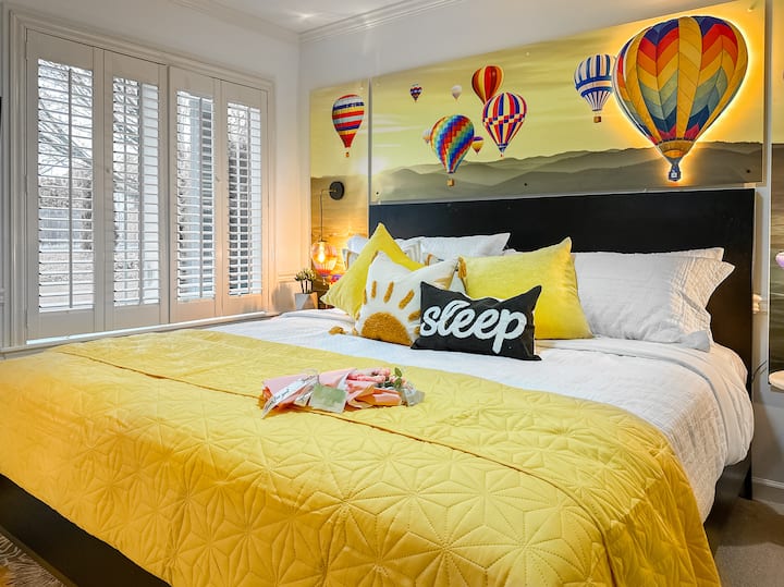 Bright & Airy Bedroom with King Bed ☀️
Wake up under a sky of hot air balloons in this dreamy king bedroom. Plush bedding, cheerful yellow accents, and natural light make this a favorite retreat.
