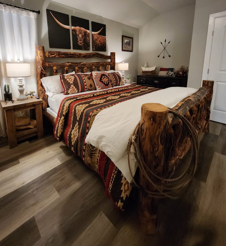 The apartment's main floor bedroom with real beetle pine King bed, ensuite bathroom with shower and ceiling fan. Get a little taste of Texas!  Bedroom is right next to kitchenette with microwave, coffee machine and fridge