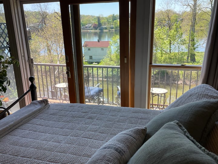 Pogled na proljeće iz glavne spavaće sobe na trećem katu.  Pogled na balkon, uvalu potoka, otok Lewis i rijeku Delaware. 
