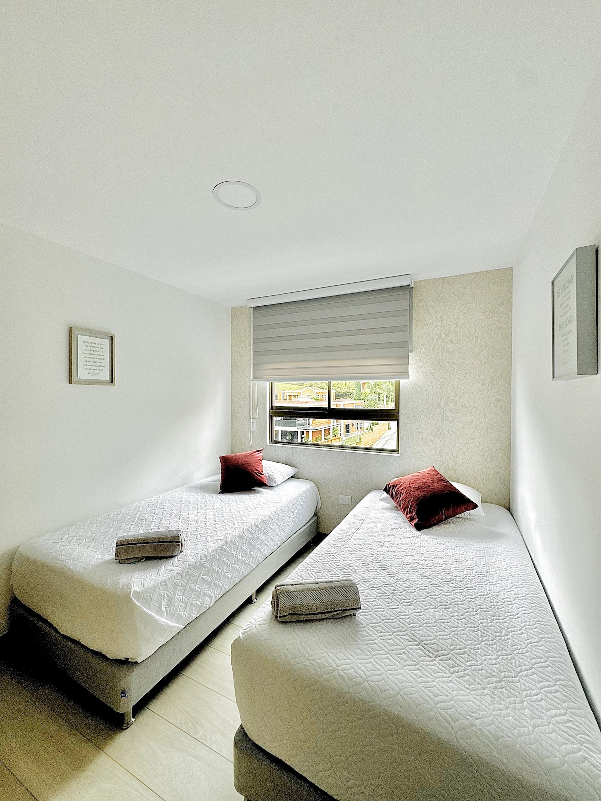 Svijetla soba s dva odvojena kreveta, besprijekornom posteljinom i udobnim ukrasnim detaljima. Prozor pruža prirodno svjetlo, ugodan pogled i svjež i prozračan ambijent tijekom dana.