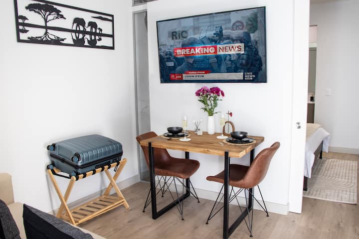 Living space: dining table, 2-seater couch, 55" Samsung smart TVs