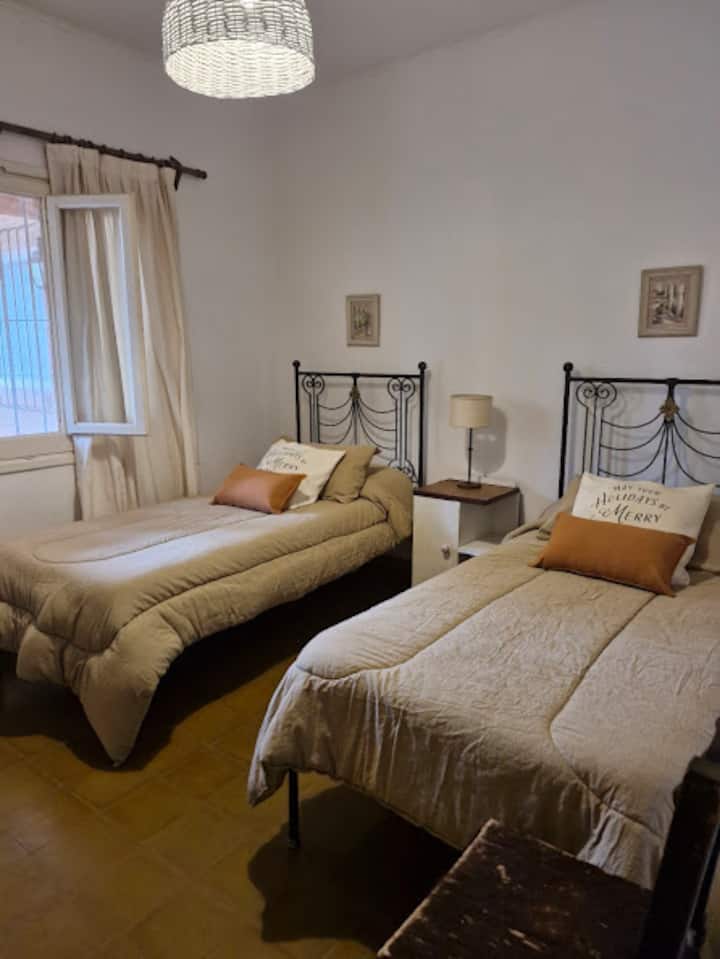 De slaapkamer heeft een kast, dressoir en tv. Raam met klamboe.  