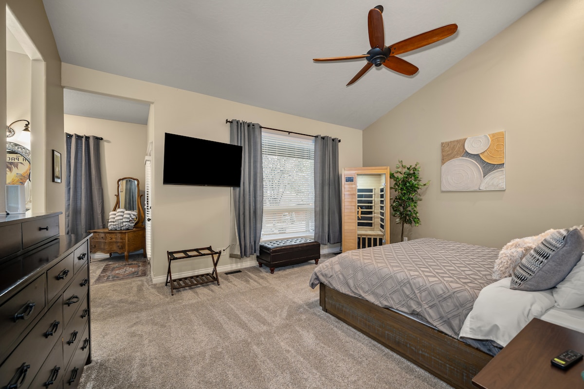 Phòng ngủ chính có TV, giường cỡ king và phòng xông hơi khô