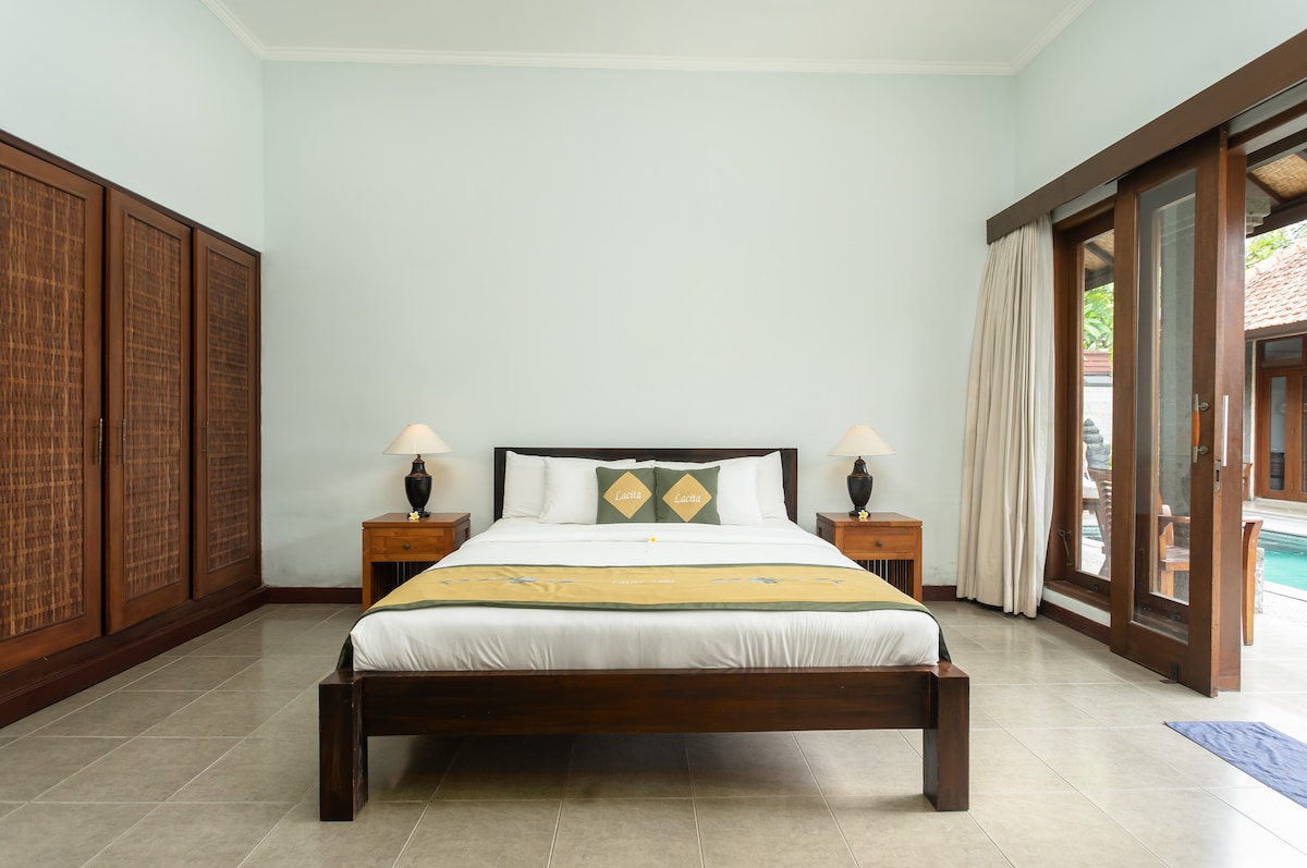 Спалнята предлага зашеметяваща гледка към басейна с модерен дизайн, оборудвана с климатик, работна зона, зона за грим и директно свързана със самостоятелната баня.