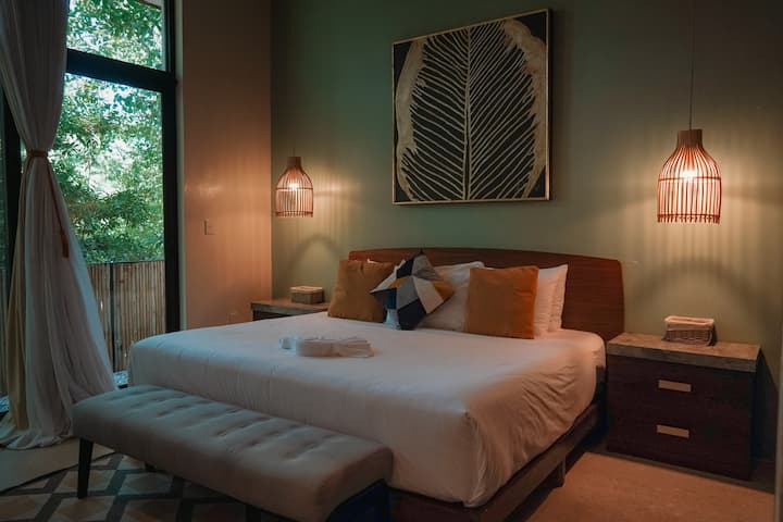 Dormitorio principal con aire acondicionado: descansa cómodamente con ropa de cama lujosa y vistas a la selva.
Baño privado de lujo: baño privado adjunto a la suite principal para mayor comodidad.