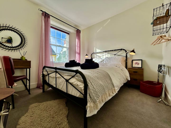 Este dormitorio un poco más pequeño está amueblado con una cama doble de estilo similar. Se compró una variedad de edredones y sábanas para atender a una variedad de personas que duermen.