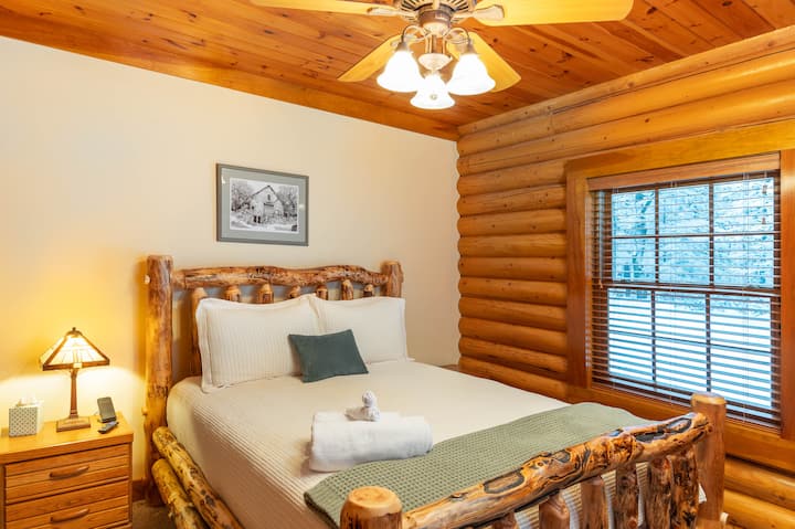 Posteľ s guľatinou veľkosti Queen.  Televízor Roku, nabíjačky telefónov, vankúše navyše, svetlo na čítanie.