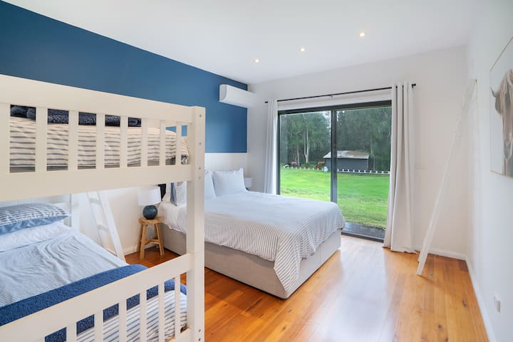 Ეს ფართო ოთახი გთავაზობთ კომფორტისა და ფუნქციონირების იდეალურ კომბინაციას, რომელიც იდეალურია ოჯახებისთვის ან ჯგუფებისთვის. Კომფორტული ორადგილიანი საწოლი და ორსართულიანი საწოლები საცხოვრებელს სახალისო, პრაქტიკულ ელემენტს ანიჭებს, იდეალურია დამატებითი სტუმრებისთვის ან ბავშვებისთვის.