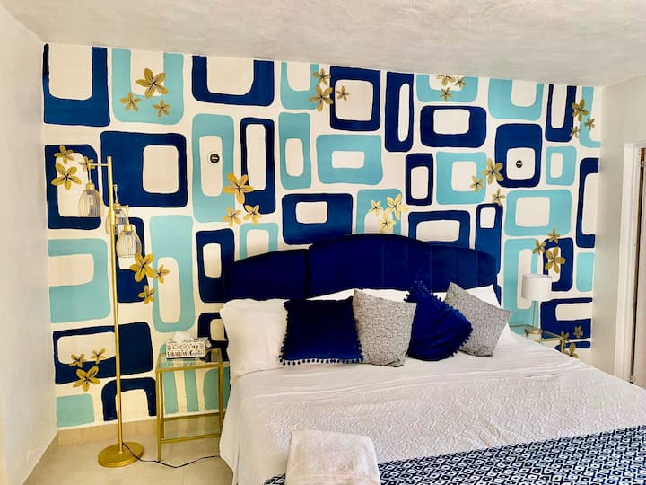 Main bedroom with firm king bed, a/c unit, ensuite bathroom, 32 inch tv with streaming apps, and large closet and workspace. 