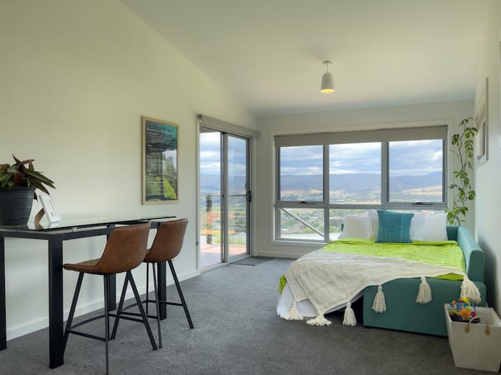 Chumba cha jua (Katika usanidi wa kitanda): Pamoja na sehemu ya kufanyia kazi, kitanda kikubwa cha godoro, mwonekano mzuri na ufikiaji wa staha, chumba hiki ni mahali pa furaha. Inaweza kutumika kama ofisi kwa wataalamu au wanafunzi na pia nafasi kubwa ya kuishi kwa familia nzima kufurahia.