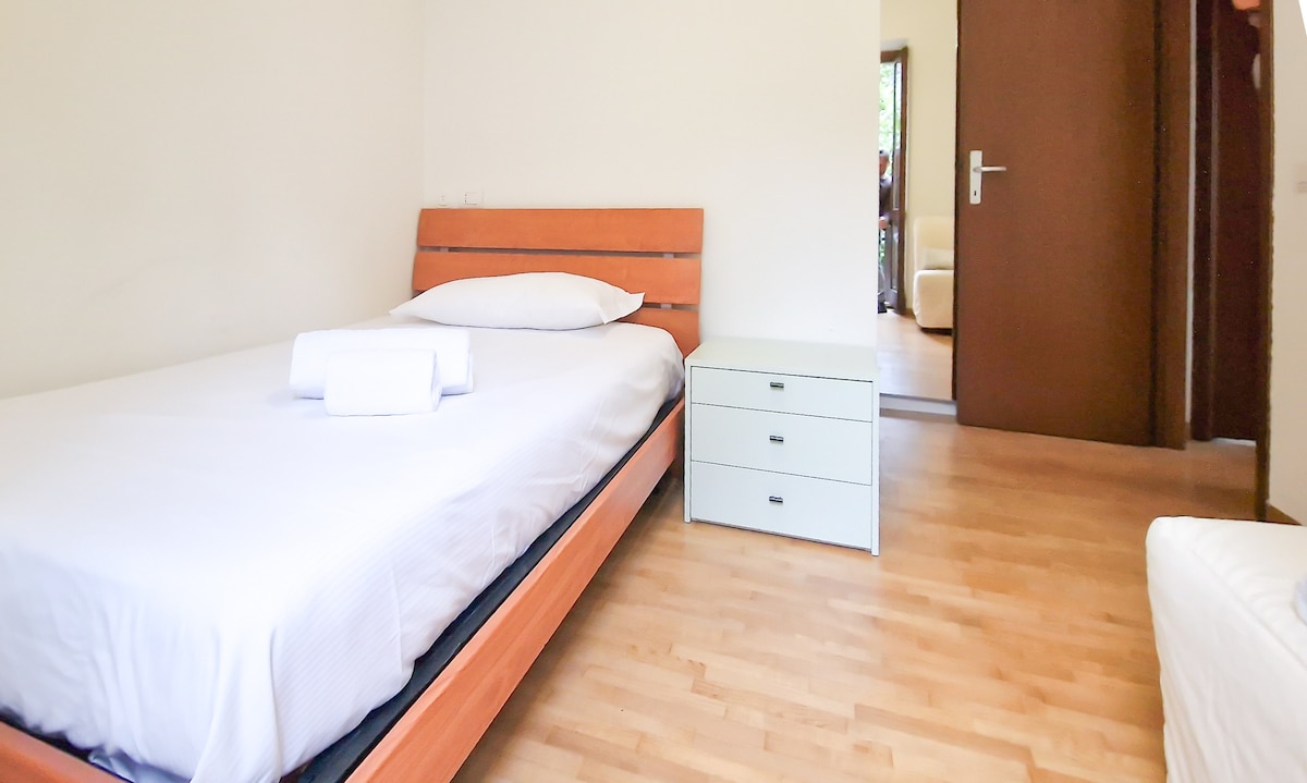 Second bedroom with two single beds and balcony overlooking Valmalenco