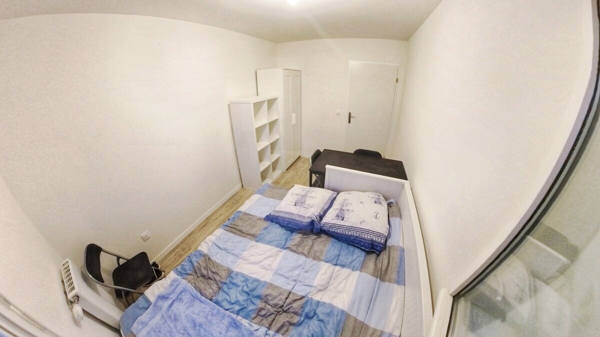 Giường có thể được kéo dài và giường đơn có thể được thay thế bằng giường đôi.  Căn phòng này có cửa sổ lớn với tầm nhìn ra đường phố.  Có 1 tủ quần áo, một kệ, một bàn và 2 ghế.