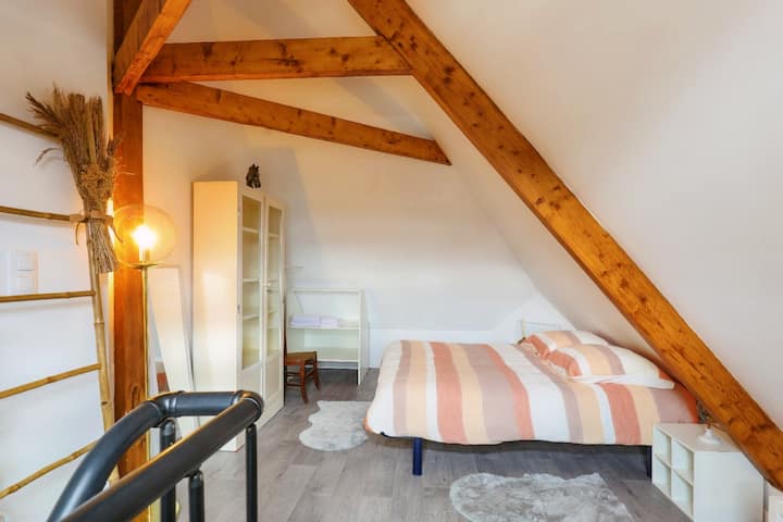 Საძინებელი სხვენის ქვეშ, დაუცველი კოჭებით, კომფორტული 140 საწოლი ზეწრებით და რბილი განათებით. Მოსახერხებელი ავეჯი და ბუნებრივი დეკორი. Თბილი და მყუდრო გარემო, იდეალურია დასვენებისთვის.