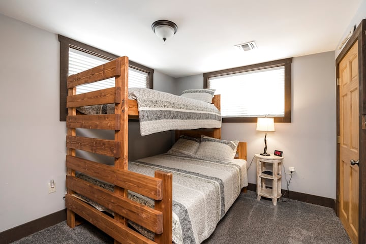 Habitación con literas en el nivel inferior. Litera amish hecha a medida. La cama inferior es una cama queen y la parte superior es una cama individual. 