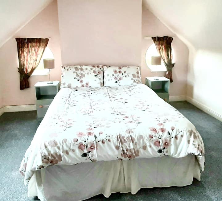 chumba cha kulala cha watu wawili kilicho na madirisha ya shimo linaloangalia bahari na ufukweni