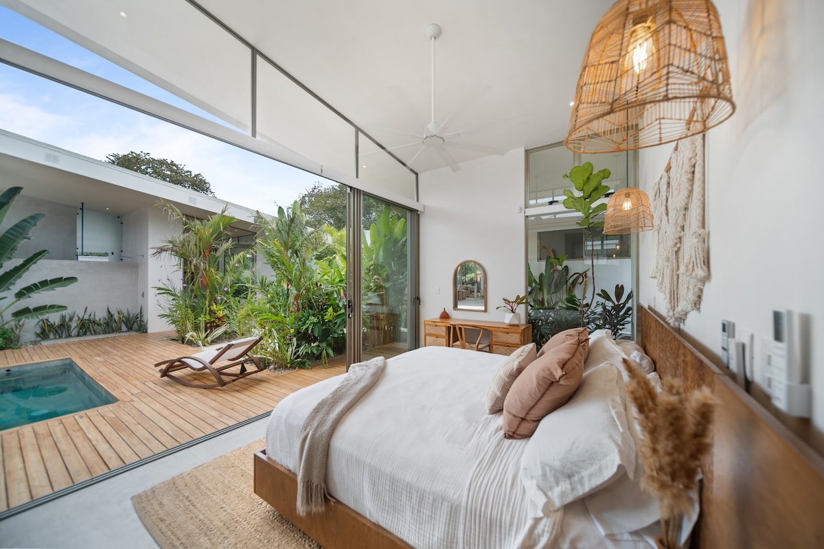 Amplio maestro con una cama tamaño king, ducha cerrada al aire libre y vestidor. Disfruta de un jardín interior, un escritorio de trabajo y grandes puertas de vidrio plegables que conducen a un patio tropical y piscina. El clic del botón crea privacidad con cortinas desplegables.