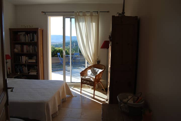 spálňa s manželskou posteľou s výhľadom na bazén, šatníková skriňa, skriňa s vešiakmi a policami.