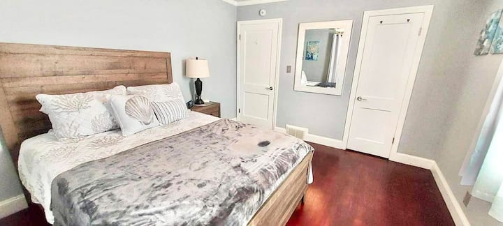 ห้องนอนพร้อมเตียงควีนไซส์ตู้เสื้อผ้าโต๊ะข้างเตียงม่านทึบแสงและตู้เสื้อผ้า  