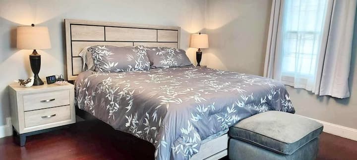 ห้องนอนชั้นหลักพร้อมเตียงคิงไซส์พร้อมตู้เสื้อผ้าโต๊ะข้างเตียง 2 ตัวตู้เสื้อผ้า 2 ตู้และทีวีพร้อม Roku