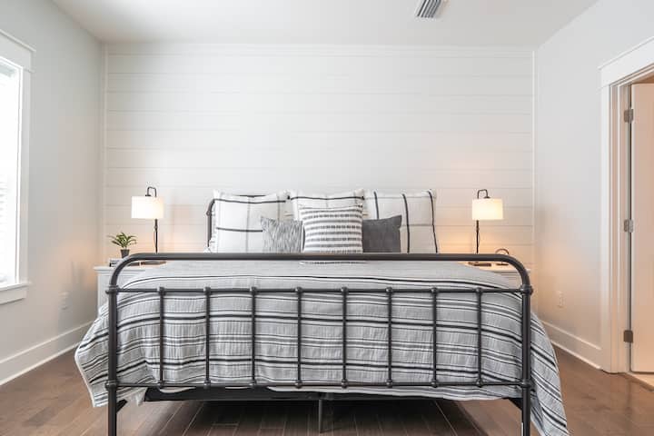 Il tuo comodo letto matrimoniale grande nella camera matrimoniale, con lampade da comodino, grande TV, sedia da lettura, cassettiera, cabina armadio e bagno padronale interno con cabina doccia e vasca da bagno separata