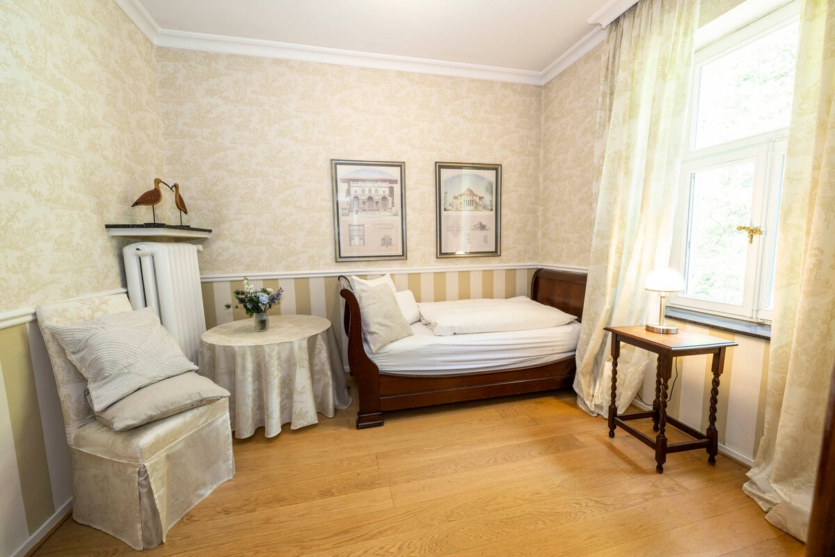 Udobna soba u Rondellu je jednokrevetna soba s klasičnim dekorom. Lako je osjećati se ugodno. Pogled vodi do ulaza, gdje magnolije cvjetaju u proljeće.
Kupaonica u sklopu apartmana ima tuš-kabinu s tuš-kabinom i WC-om.