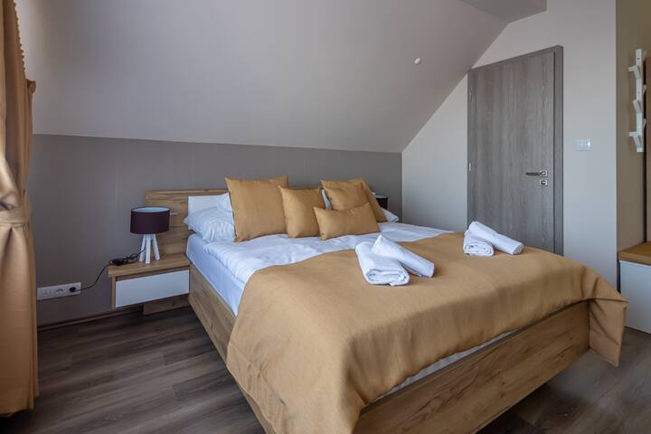 Krevati ka një dyshek të rehatshëm. Krevati mund të hyjë nga dera e meletit në banjën tënde private.