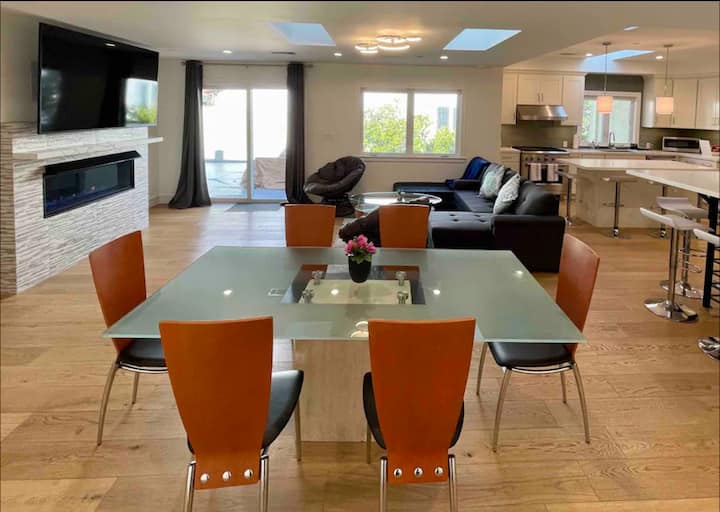 Gran habitación con mesa de comedor de vidrio con base de mármol Carrera, 6-8 sillas de cuero genuinas italianas, sofá cama, tumbona de cuero, 2 sillas papasan, conexión a la barra portátil y cocina abierta