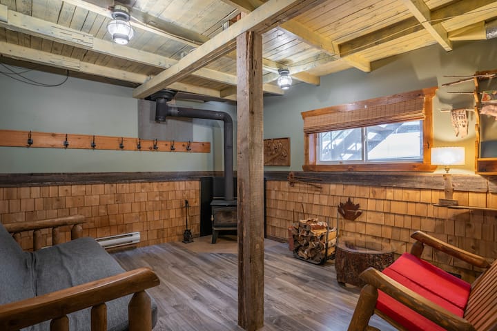 Sala de estar en el sótano con chimenea de leña y futón doble.