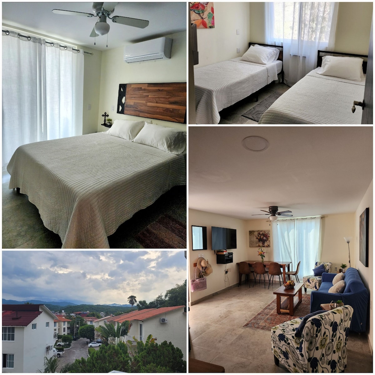 The main bedroom is furnished with a queen bed, complemented by neutral bedding and natural light from the large window. The second bedroom contains two twin beds, with light curtains enhancing the airy feel. A living area features modern furniture, a dining table, and a view of the surrounding mountains.