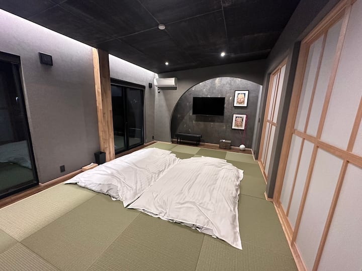 日本の布団を着た伝統的な畳のお部屋で眠りましょう。 このお部屋は布団6枚までご利用いただけます。 必要に応じて、2階のリビングルームで使用できる予備の布団もあります。 