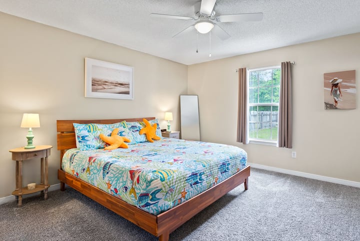 “Rest easy in this cozy bedroom with a plush bed, natural light by day, and room-darkening curtains for a peaceful night’s sleep.”