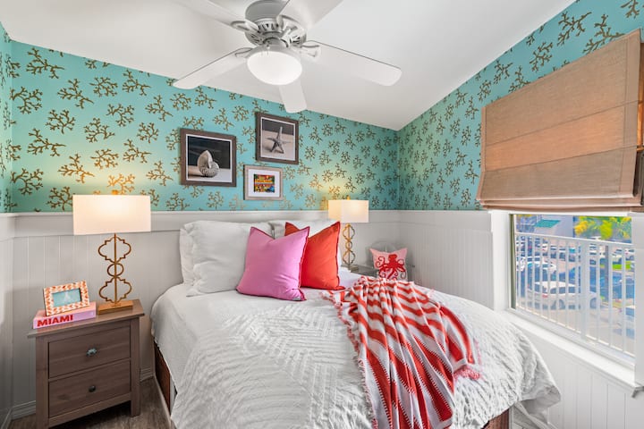 Dormitorio de invitados con cama tamaño queen y mucho espacio de almacenamiento debajo de la cama. Todas las habitaciones tienen cortinas opacas y televisores inteligentes.