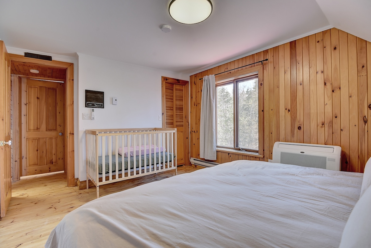 加大双人床卧室，配有婴儿盆床、公园和更衣桌