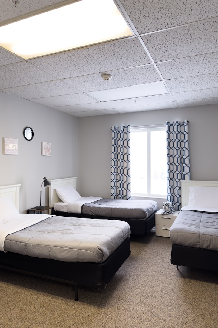 Bedroom 7 features 3 twin beds and an attached half bathroom.