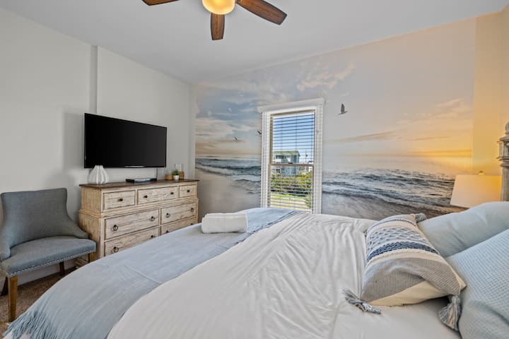 ห้องนอน 5 มีเตียงคิงไซส์ ภาพวาดฝาผนังขนาดใหญ่ และสมาร์ททีวี