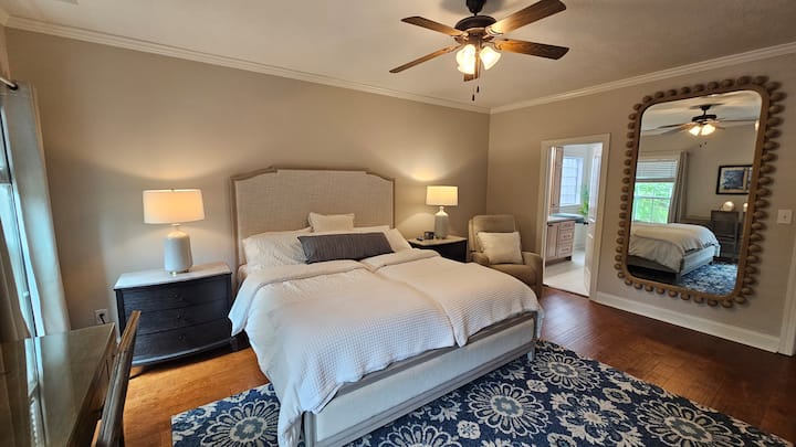 Modernizovaná hlavná spálňa. Matrace s nastaviteľnou základňou Split King (Twin XL) s diaľkovým ovládaním. Nadrozmerné koncové stolíky na odkladanie vecí pri posteli. Rohové sklápacie kreslo. 224 cm široké zrkadlo.