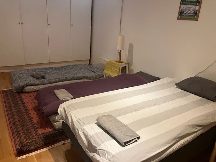 Kitanda kimoja chenye upana wa sentimita 100 na magodoro 2 yaliyo sakafuni.