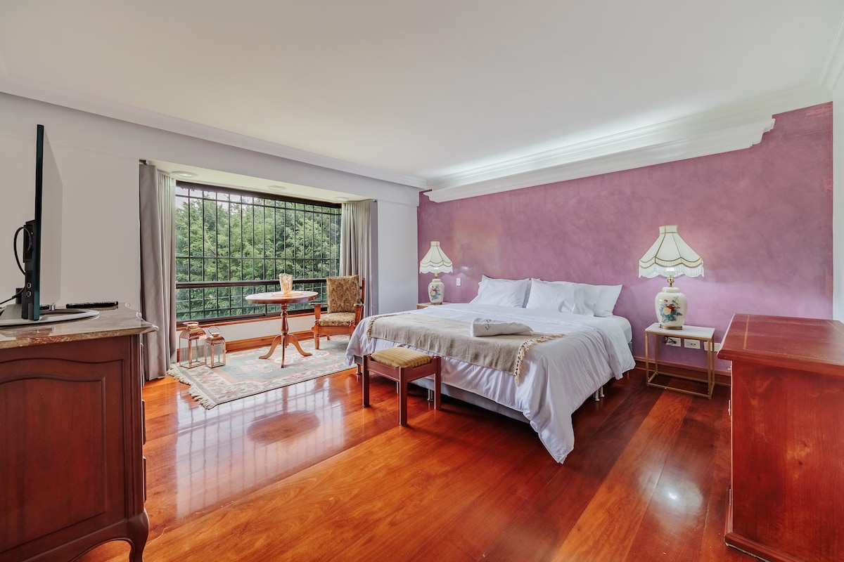 Habitación #1 principal con luces indirectas acabados premium, madera brasileña importada, cama king, walking closet, baño privado, TV inteligente y cortinas blackout para que descanses en la tranquilidad del campo pero a solo minutos de la ciudad.