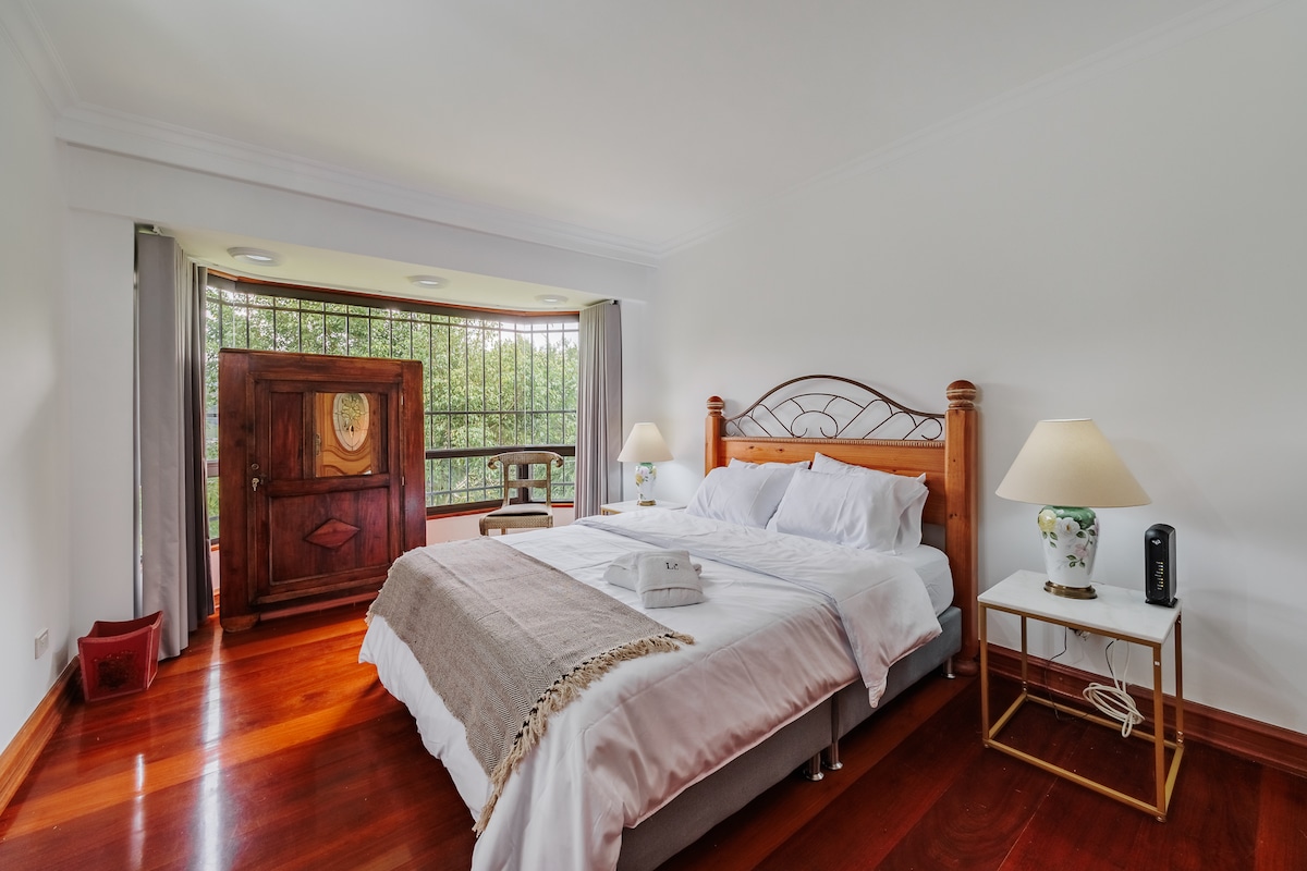 Habitación #4. Elegante habitación con TV con Roku, piso de madera, cortinas blackout y exquisita cama tamaño Queen. 