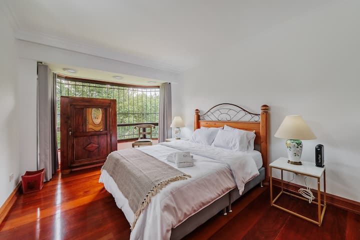 Habitación #4. Elegante habitación con TV con Roku, piso de madera, cortinas blackout y exquisita cama tamaño Queen. 