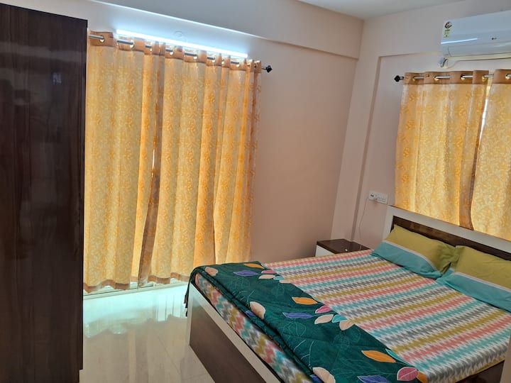 设备齐全的空调卧室，配有卫生间，包括床、衣柜、分体式空调、照明以及舒适的床上用品和装饰，营造出一片放松的空间。 