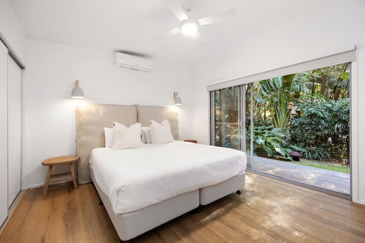 استمتع بالراحة في غرفة النوم المنفصلة في الفيلا، مع إمكانية الوصول إلى الهواء الطلق والتبريد.