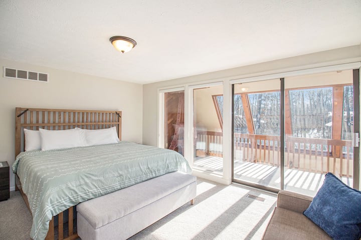 Dos mesitas de noche a lo largo de la cama equipadas con carga inalámbrica e iluminación ambiental.