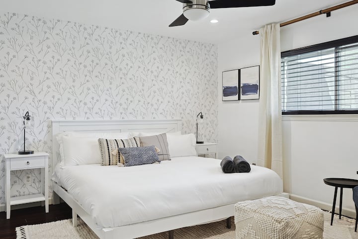 تجمع الغرفة الأنيقة بين الرقي والراحة، مما يوفر مساحة هادئة لقضاء ليلة نوم جيدة. يجعل السرير الفخم والديكور الأنيق والتخزين الواسع هذه الغرفة ملاذًا رائعًا لأي ضيف.