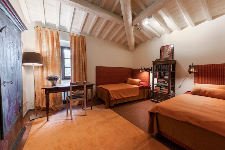 Orange room with single beds and private study nook