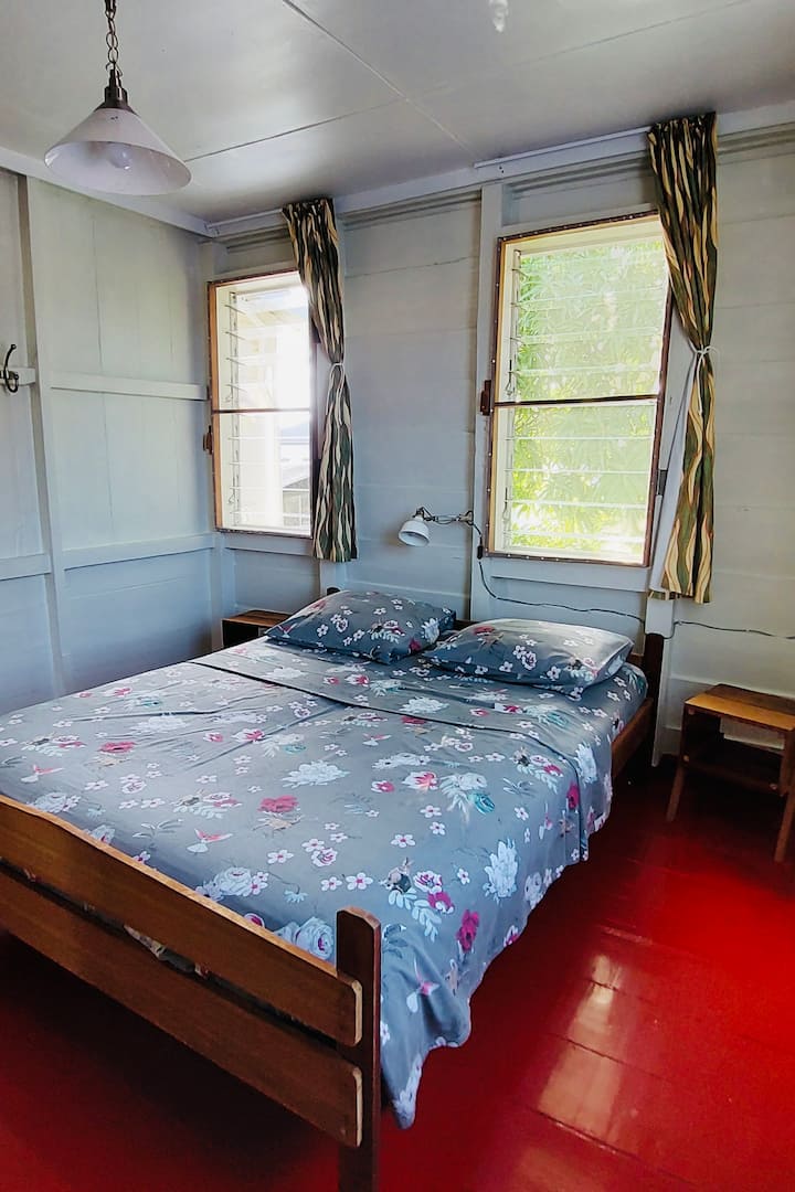 Stredná spálňa v zadnej časti domu s výhľadom na dvor. Táto spálňa má manželskú posteľ s rozmermi 160 x 200 cm, 2 nočné stolíky, jednoduchú šatníkovú skriňu a písací stôl.
Chladenie/ventialing pomocou tichého nástenného ventilátora