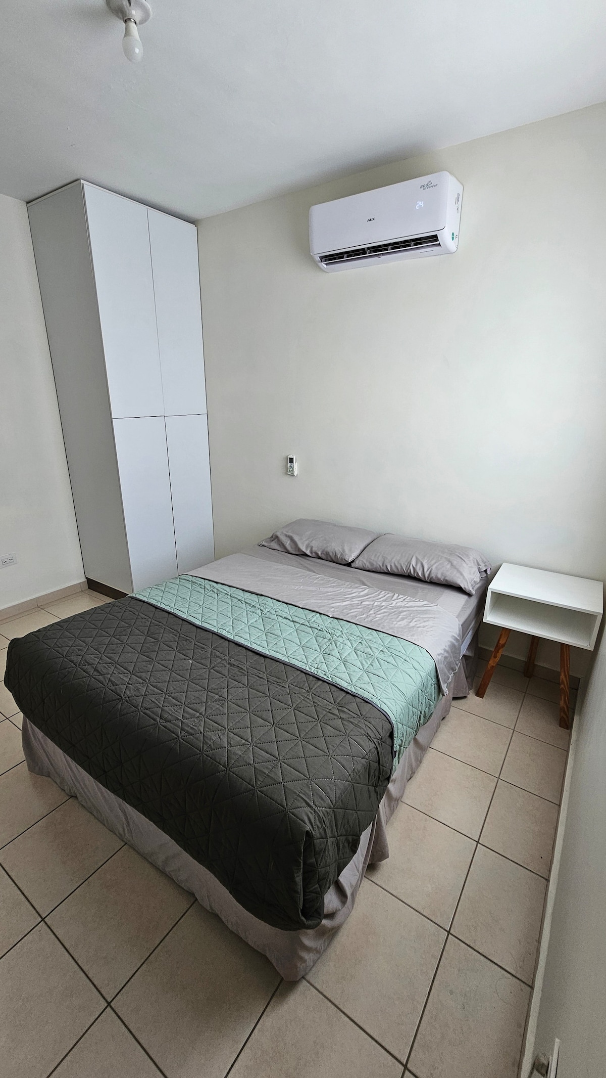 ห้องนอนพร้อมเตียงคู่ทีวีตู้เสื้อผ้าและลิ้นชัก