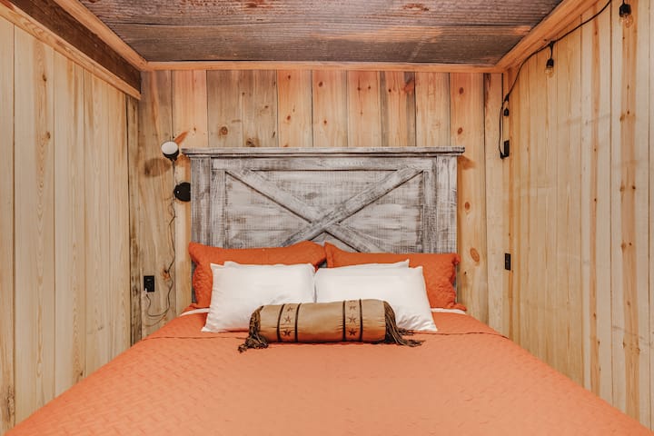 El dormitorio 1 está en la planta baja de Hickory Nut House.  Es una cama tamaño king de California con asiento de amor, unidad de aire acondicionado/calentador de ventana, persianas opacas y cafetería.  Es en parte subterráneo y es fresco incluso en el calor del verano. 