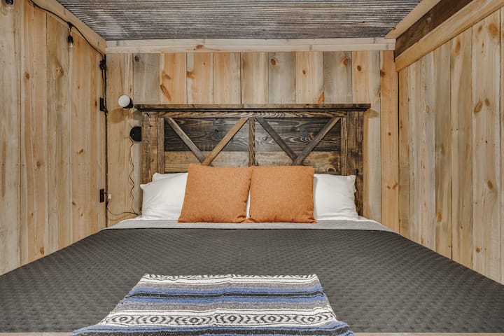 El dormitorio 1 está en la planta baja de Hickory Nut House.  Es una cama tamaño king con asiento de amor, unidad de aire acondicionado/calentador de ventana, persianas opacas y barra de café.  Es en parte subterráneo y es fresco incluso en el calor del verano. 